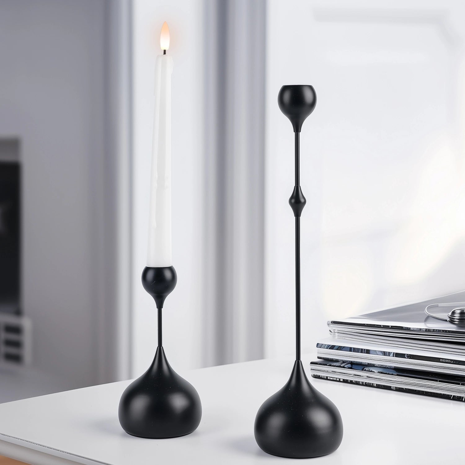Two black decorative candle holders on a surface with a blurred background#color_matte-black