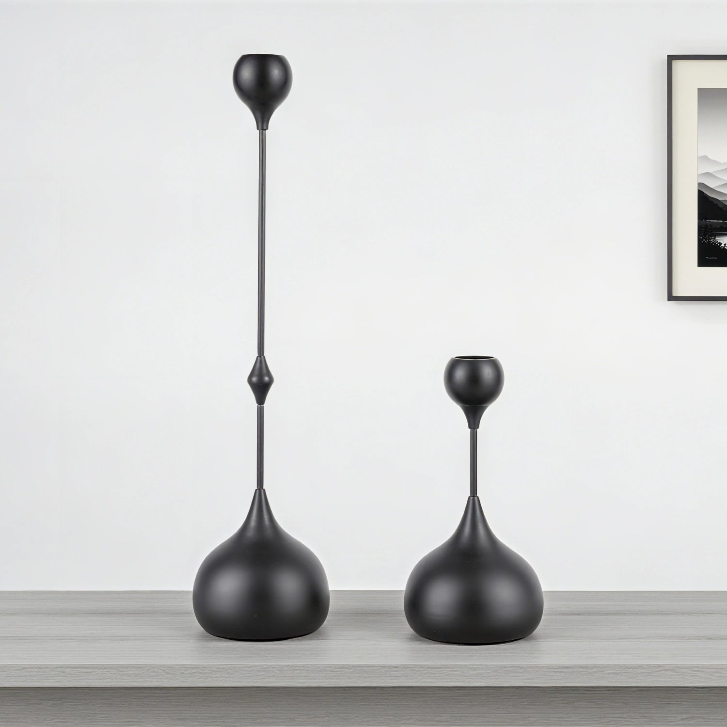 Two black decorative vases on a wooden surface with a white wall background#color_matte-black