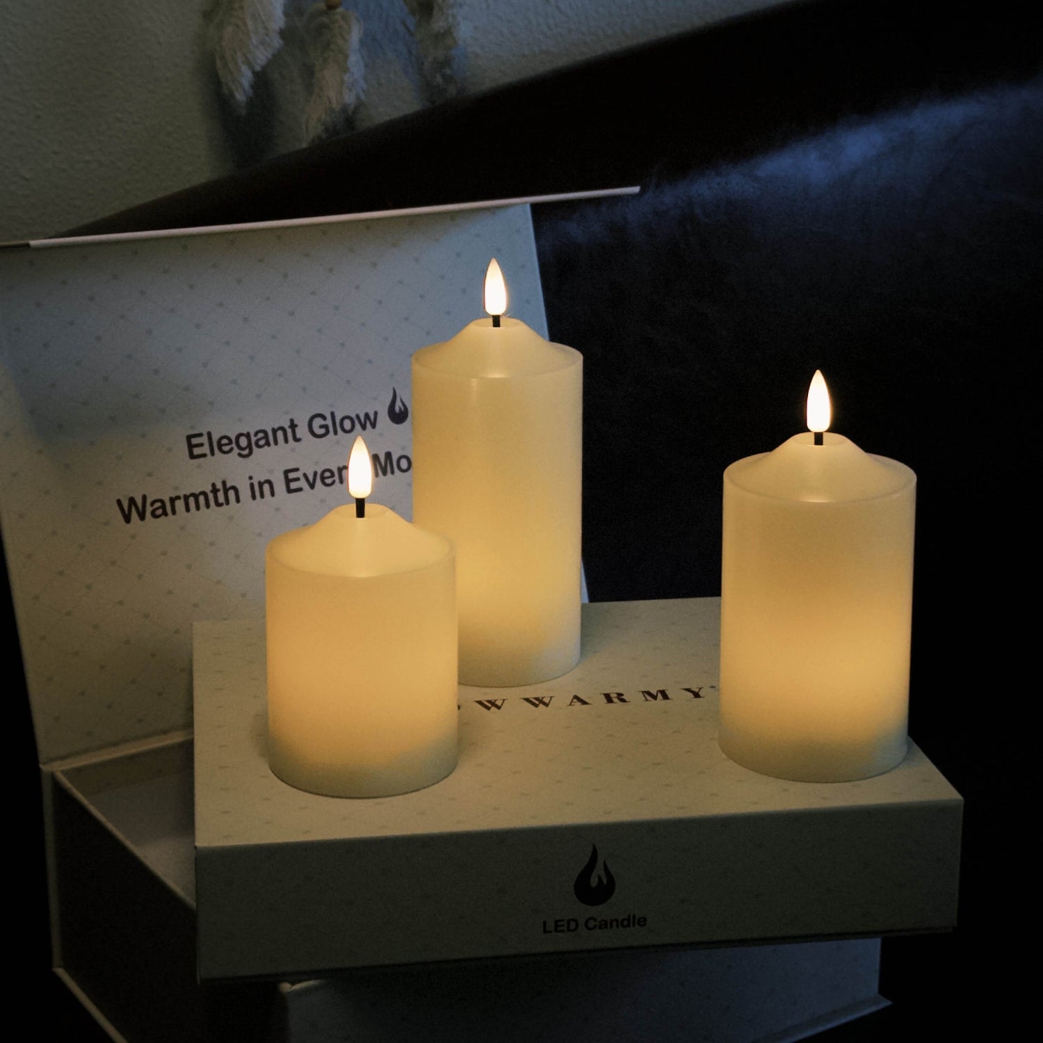 Three LED candles on a box with 'Elegant Glow' branding.