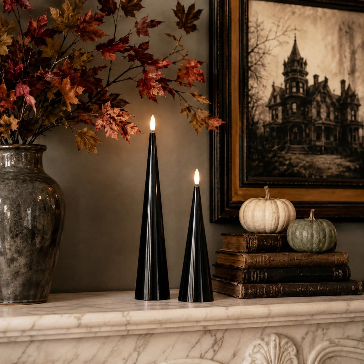 Black cone-shaped candles with lit flames on a table with Halloween decorations.
