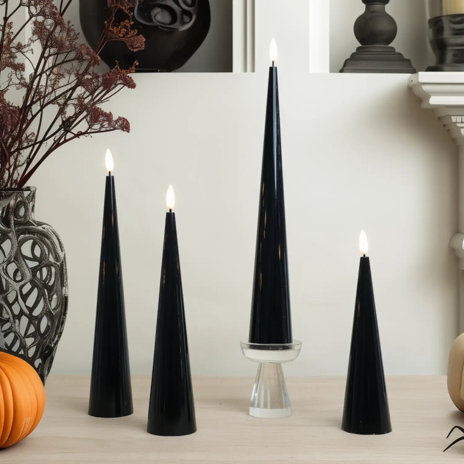 Black cone-shaped candles on a table with decorative elements.#color_shiny-black