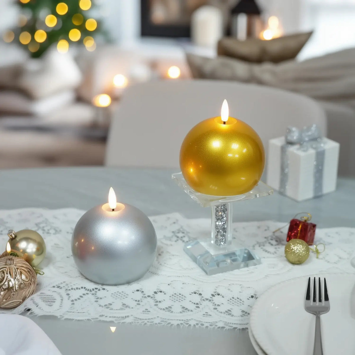 Gold candle on a wooden base with Christmas decorations in the background