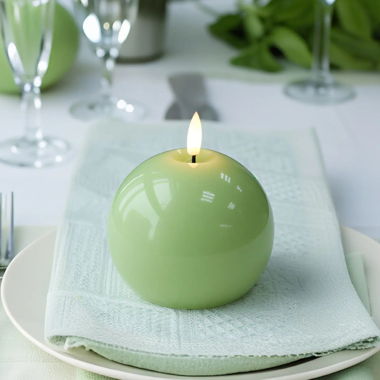 Green candle on a white plate with a white napkin#color_shiny-green