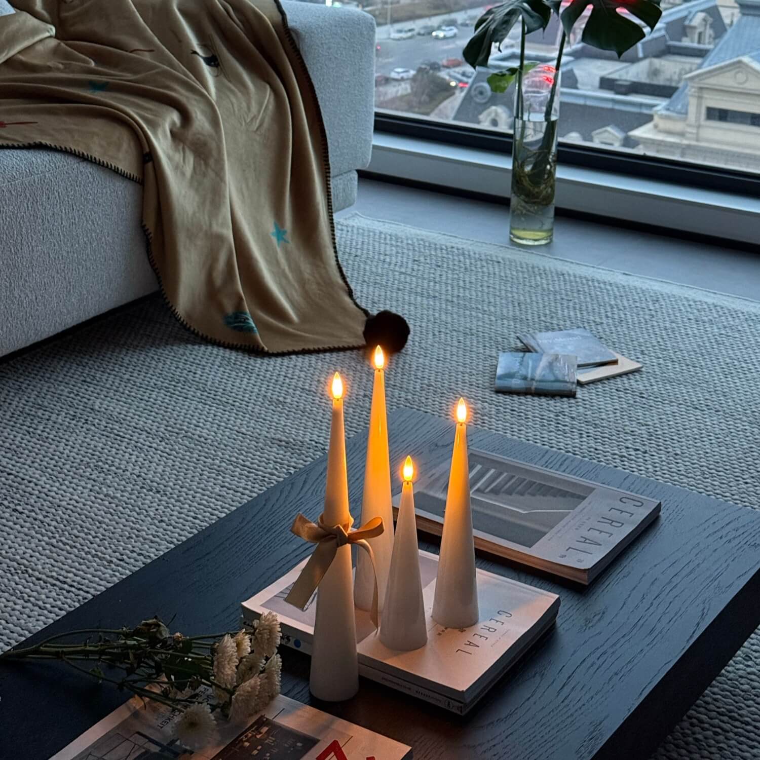 Candle holder with lit candles on a coffee table in a living room.