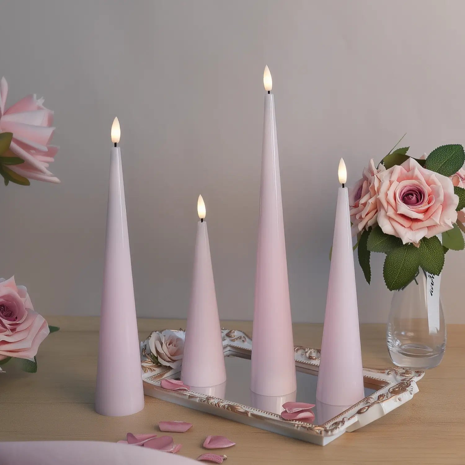 Set of three pink candles on a surface with decorative items in the background#color_shiny-pink