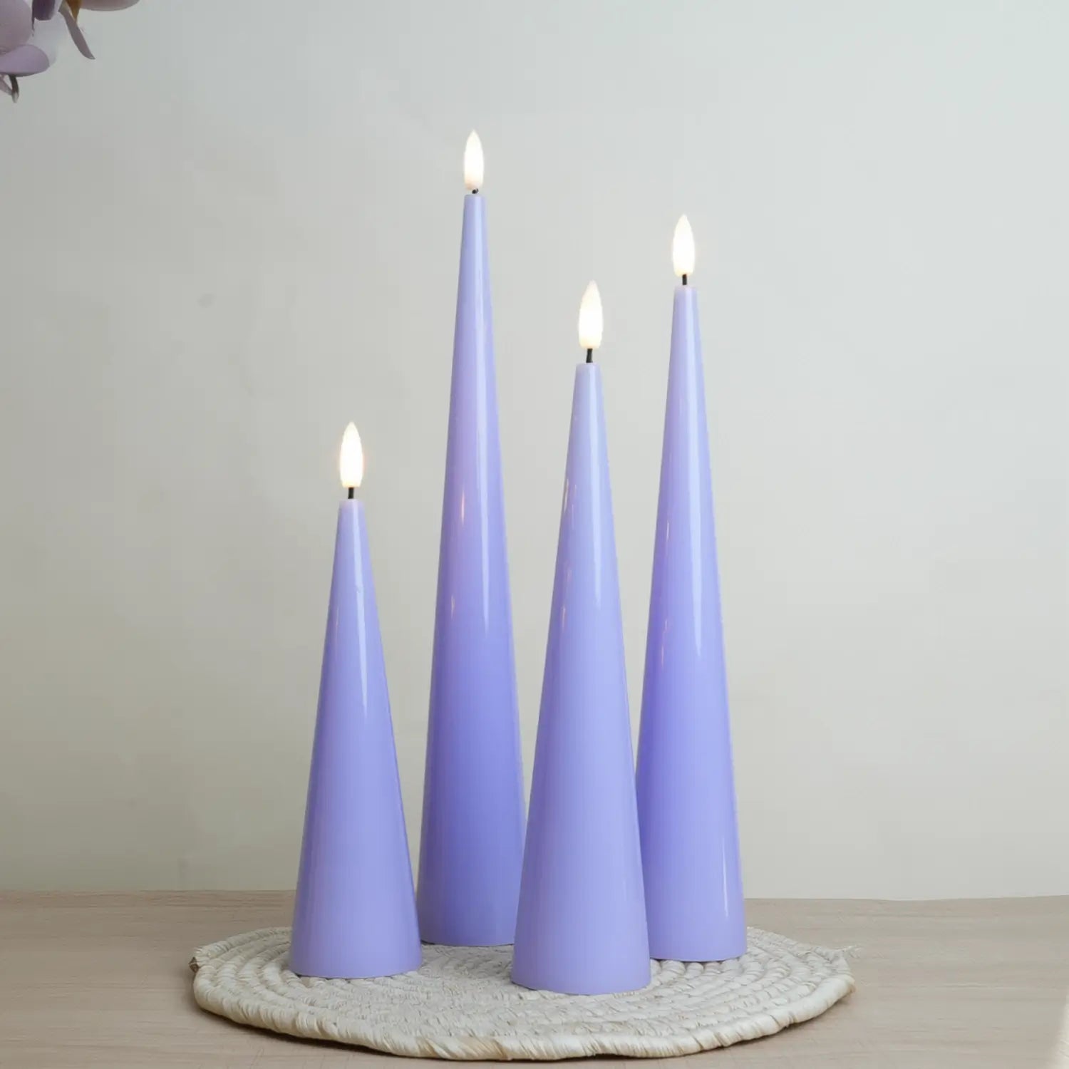 Set of four purple candles on a textured surface with a neutral background#color_shiny-purple