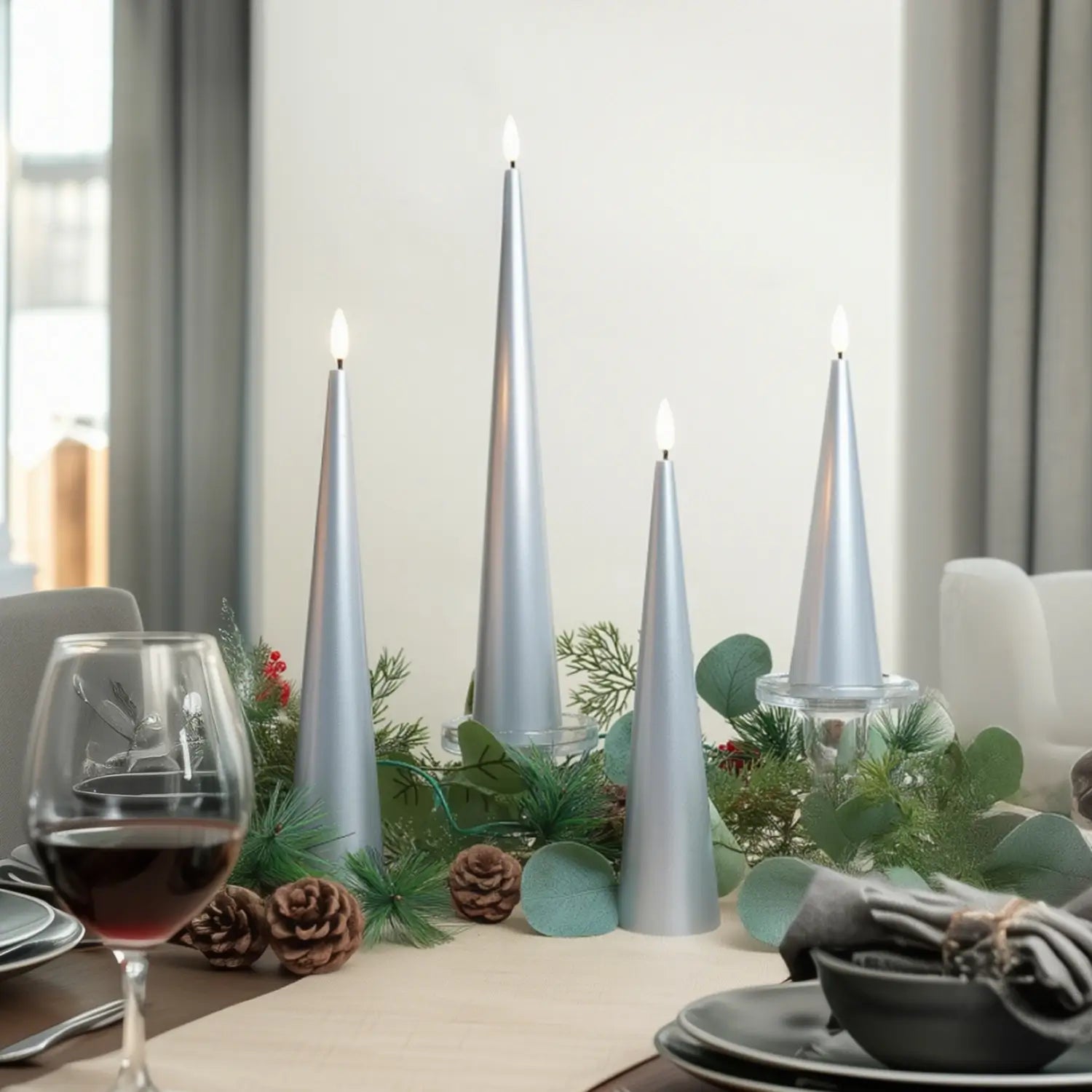 Decorative table setting with silver candles, greenery, and a glass of red wine.#color_lacquered-silver