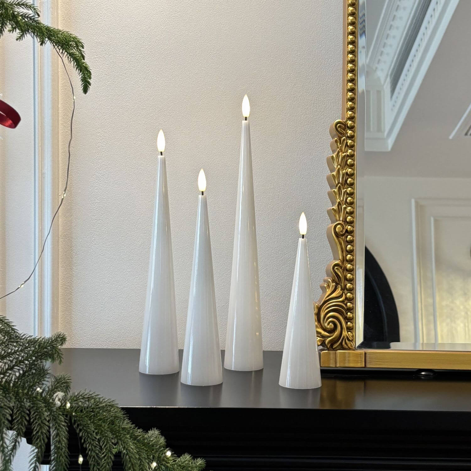 Decorative setup with white candles, pumpkins, and a skull on a neutral background#color_shiny-white