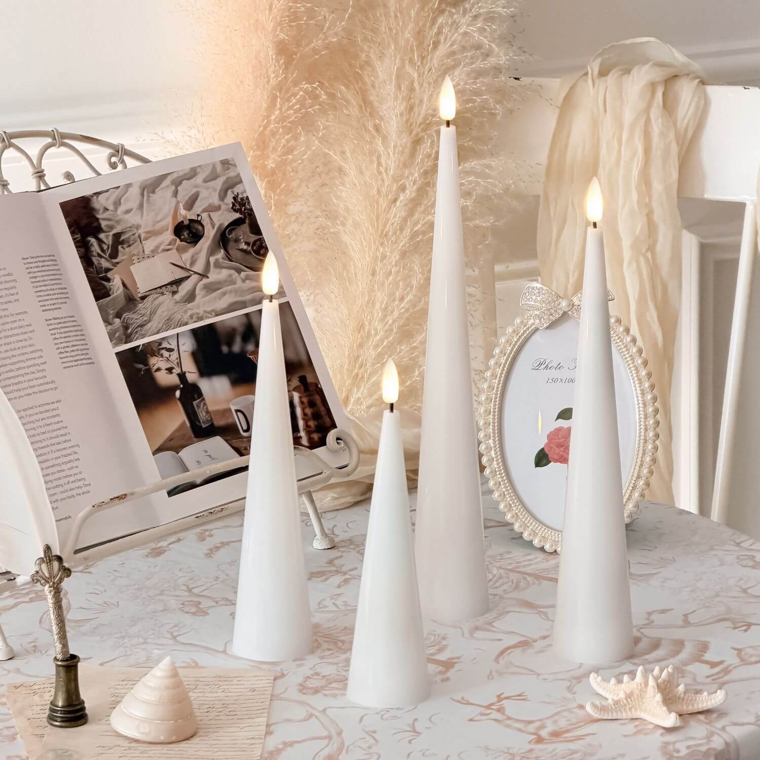 Decorative setup with white candles, pumpkins, and a skull on a neutral background#color_shiny-white
