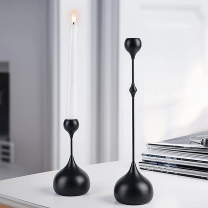 Two black decorative candle holders on a surface with a blurred background