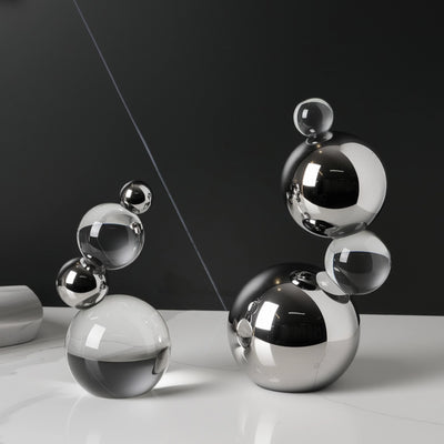 Set of metallic spherical objects on a reflective surface with a dark background