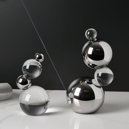 Set of metallic spherical objects on a reflective surface with a dark background