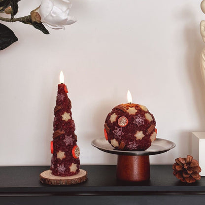 Decorative candles on a wooden base with a Christmas tree in the background