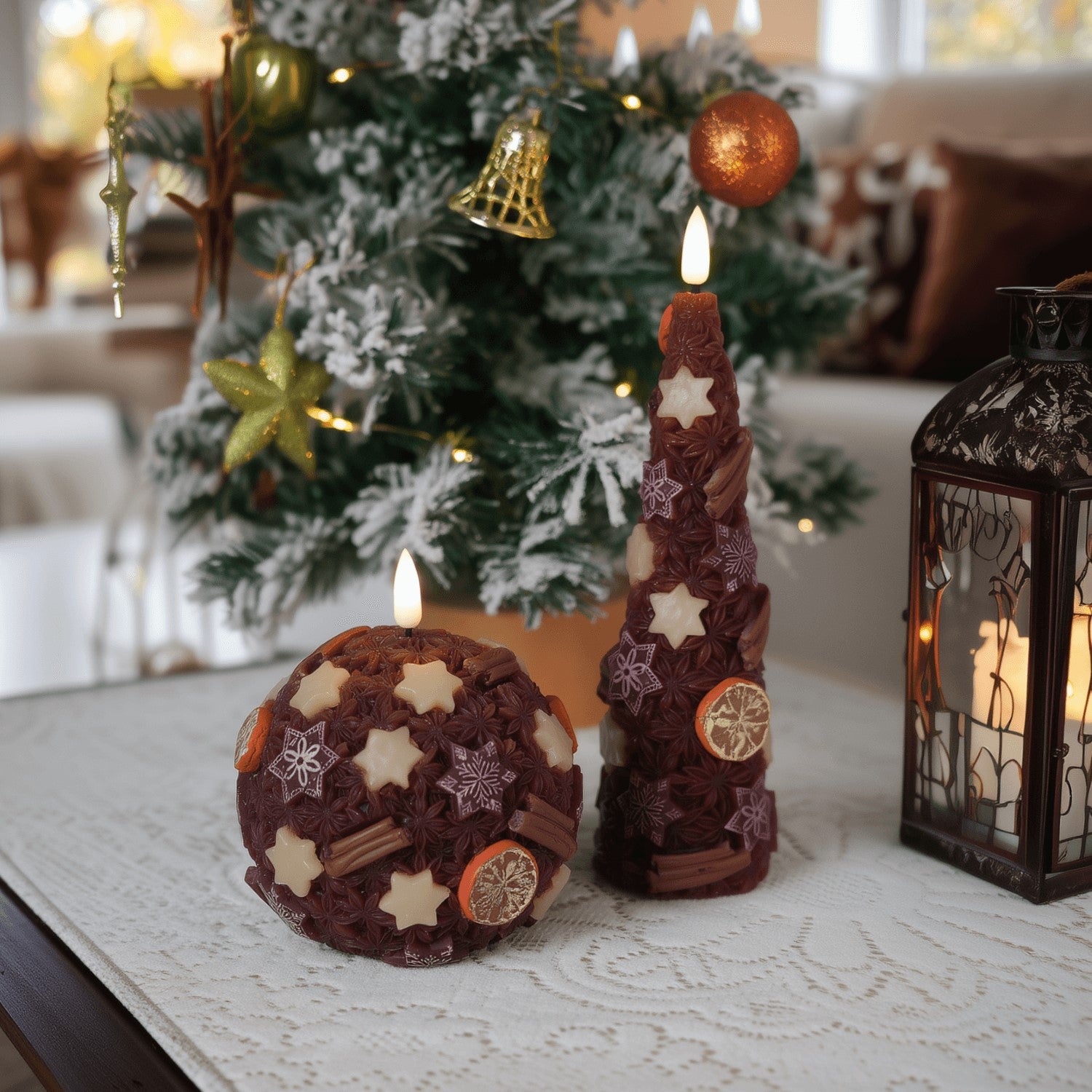 Decorative candles with star patterns on a table in front of a Christmas tree.