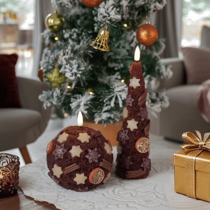 Decorative candles with star and snowflake patterns on a table in front of a Christmas tree.
