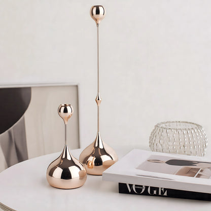 Two rose gold decorative vases on a surface with a magazine in the background.