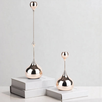 Two rose gold decorative objects on white books against a light gray background