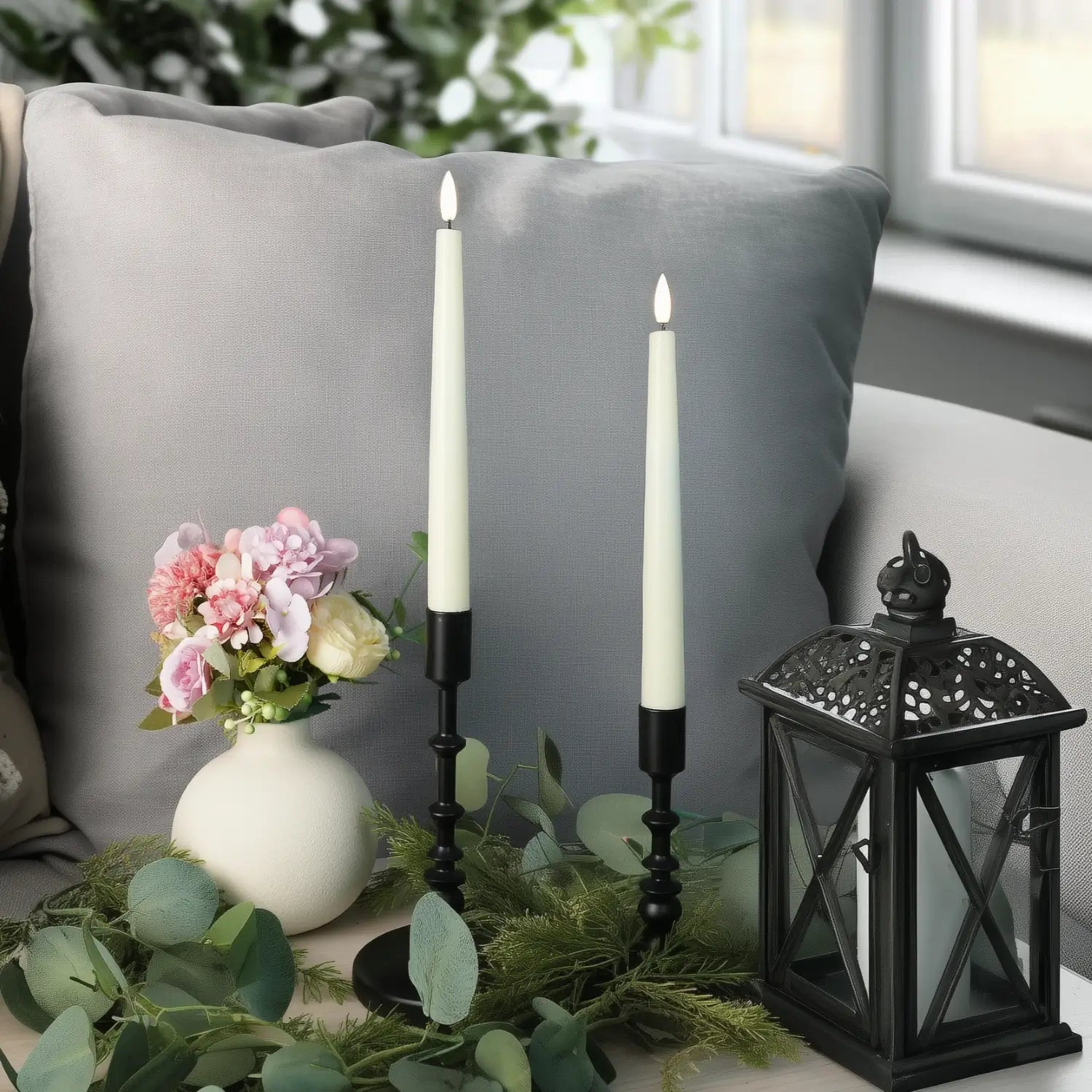 Four tall candles in gold candle holders on a neutral background#color_ivory