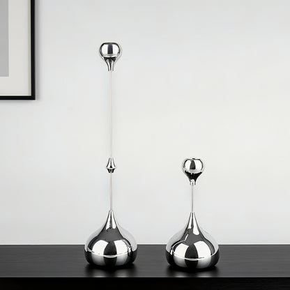 Two silver decorative vases on a dark surface with a light gray background