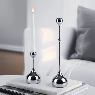 Two silver candle holders on a book with a blurred background
