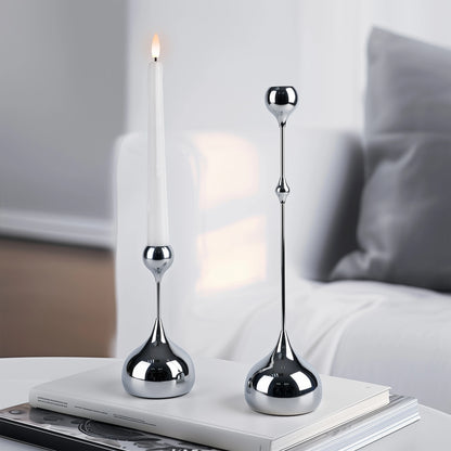 Two silver candle holders on a book with a blurred background