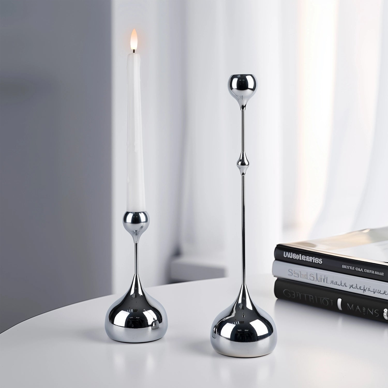 Two silver candle holders on a white surface with a blurred background