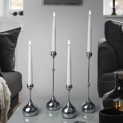 Two silver decorative vases on white surfaces with a light gray background