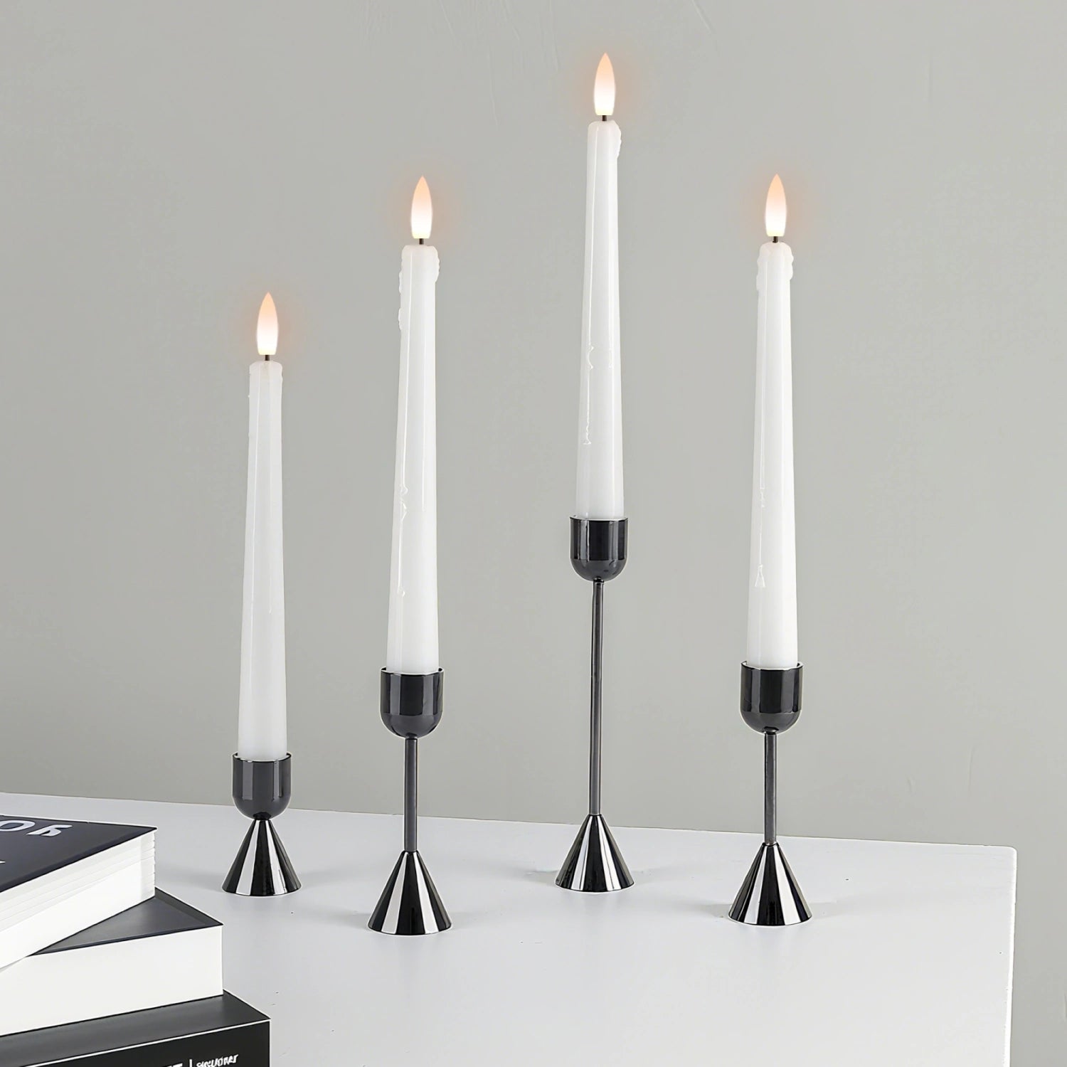 Set of four candlesticks with lit candles on a gray background#color_metal-black