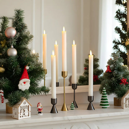 Set of black metal candle holders on a white surface with a blurred background