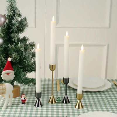 Set of black metal candle holders on a white surface with a blurred background