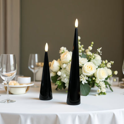 Black cone-shaped candles with lit flames on a table with Halloween decorations.