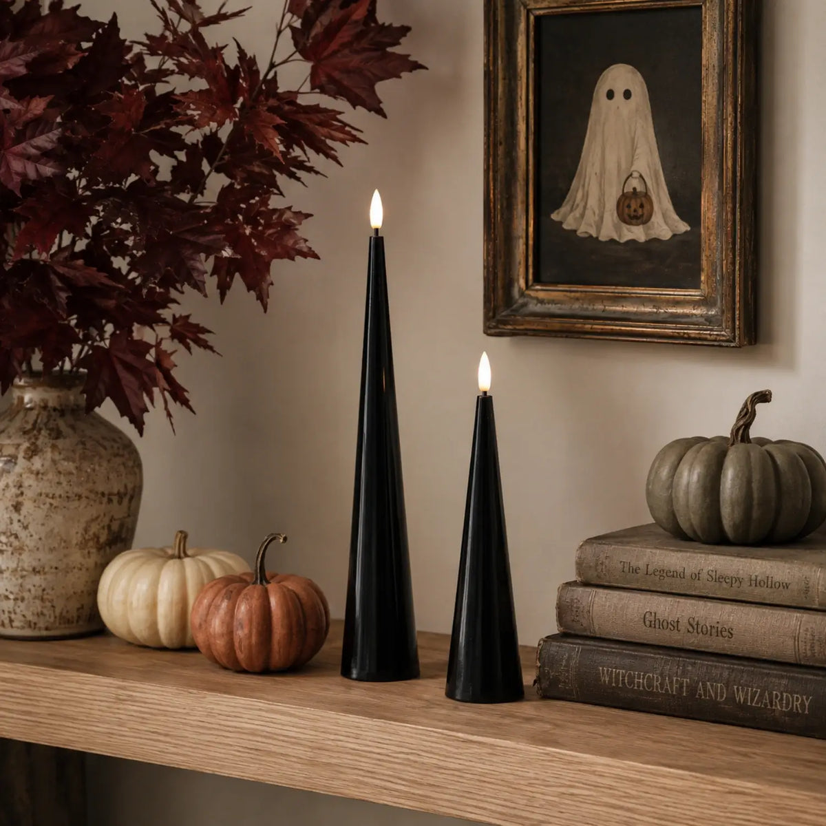 Black cone-shaped candles with lit flames on a table with Halloween decorations.#color_shiny-black