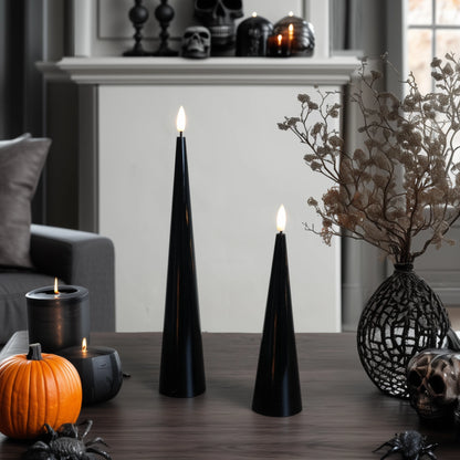 Black cone-shaped candles on a table with decorative elements in a room setting.