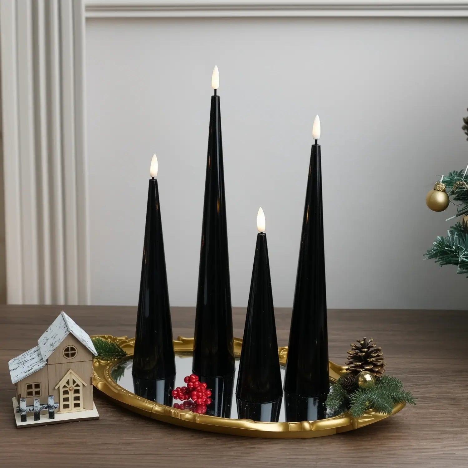 Black candles on a wooden base with a Christmas tree in the background