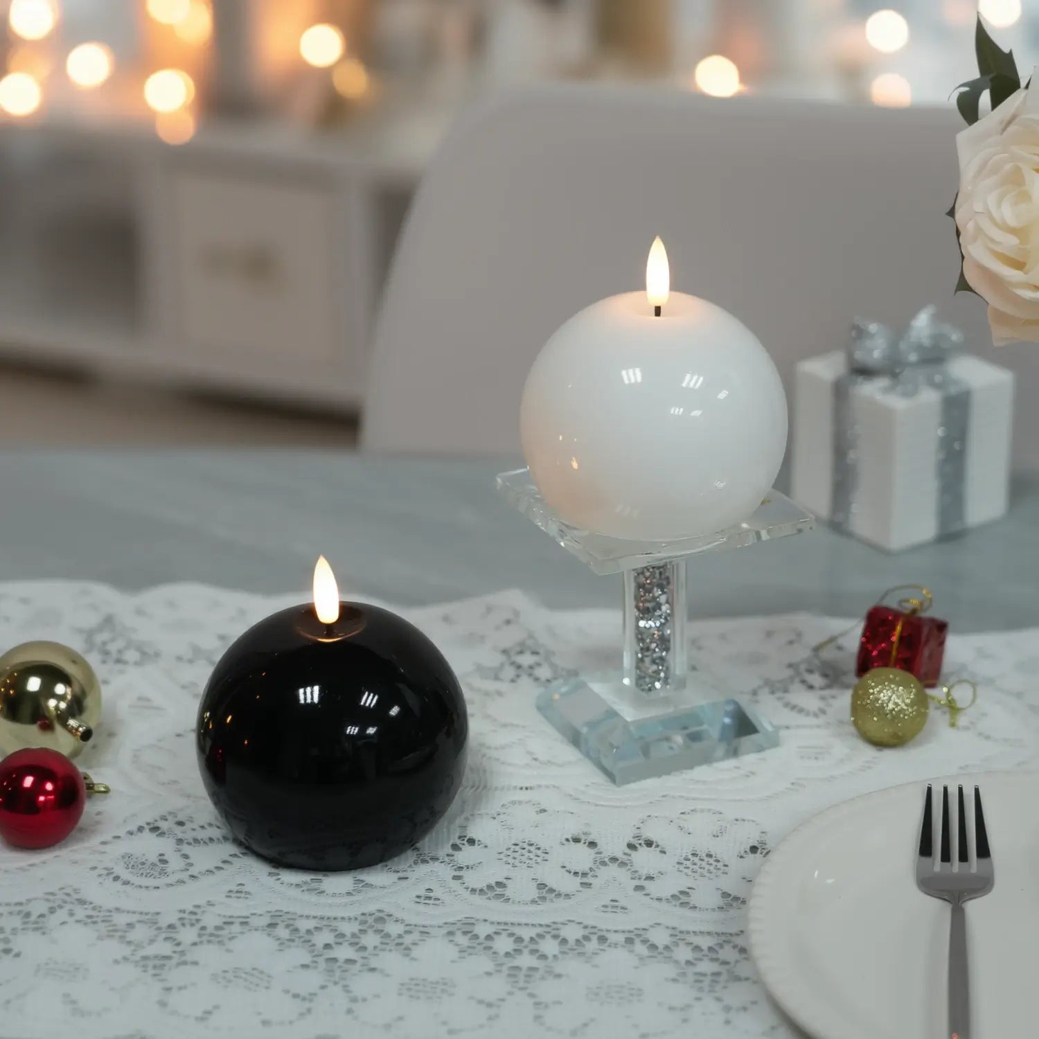 White spherical candle on a concrete tray with flowers on a wooden table