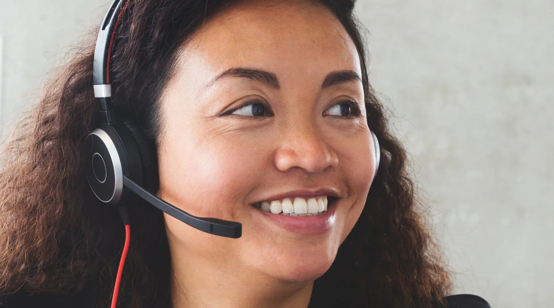 Woman wearing a headset with a neutral background