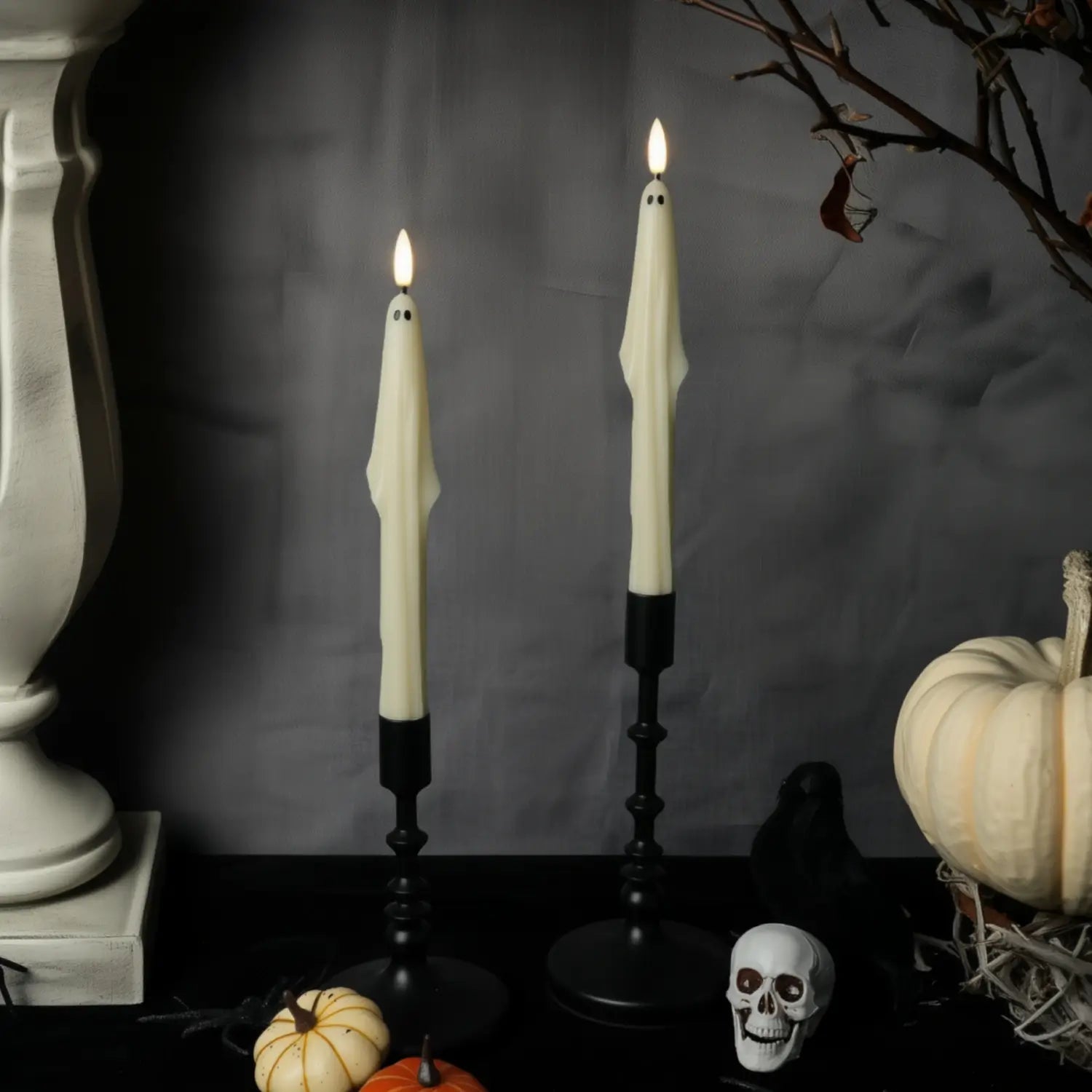 Halloween-themed candles with pumpkins and a skull on a dark background