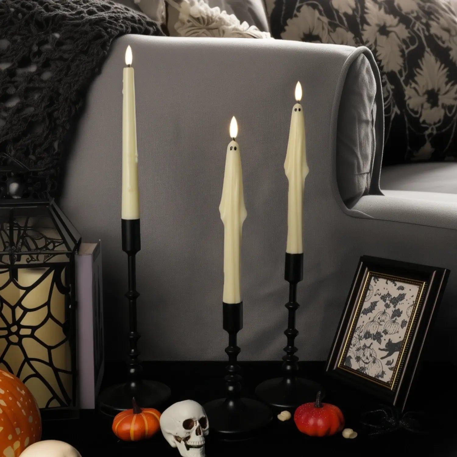 Halloween-themed decor with ghostly candles on a gray couch.