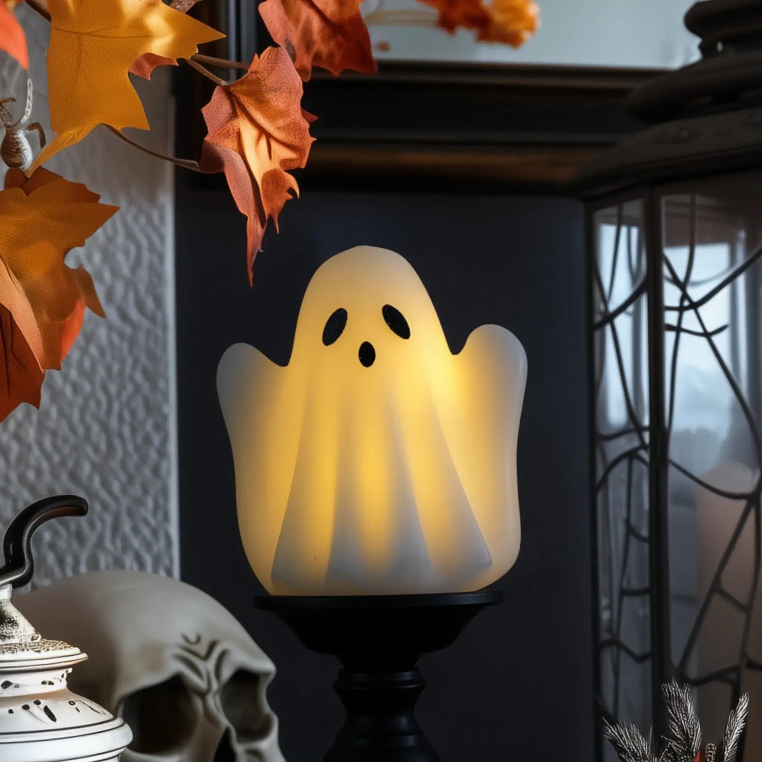 Ghost-shaped lamp with autumn leaves and a skull in the background