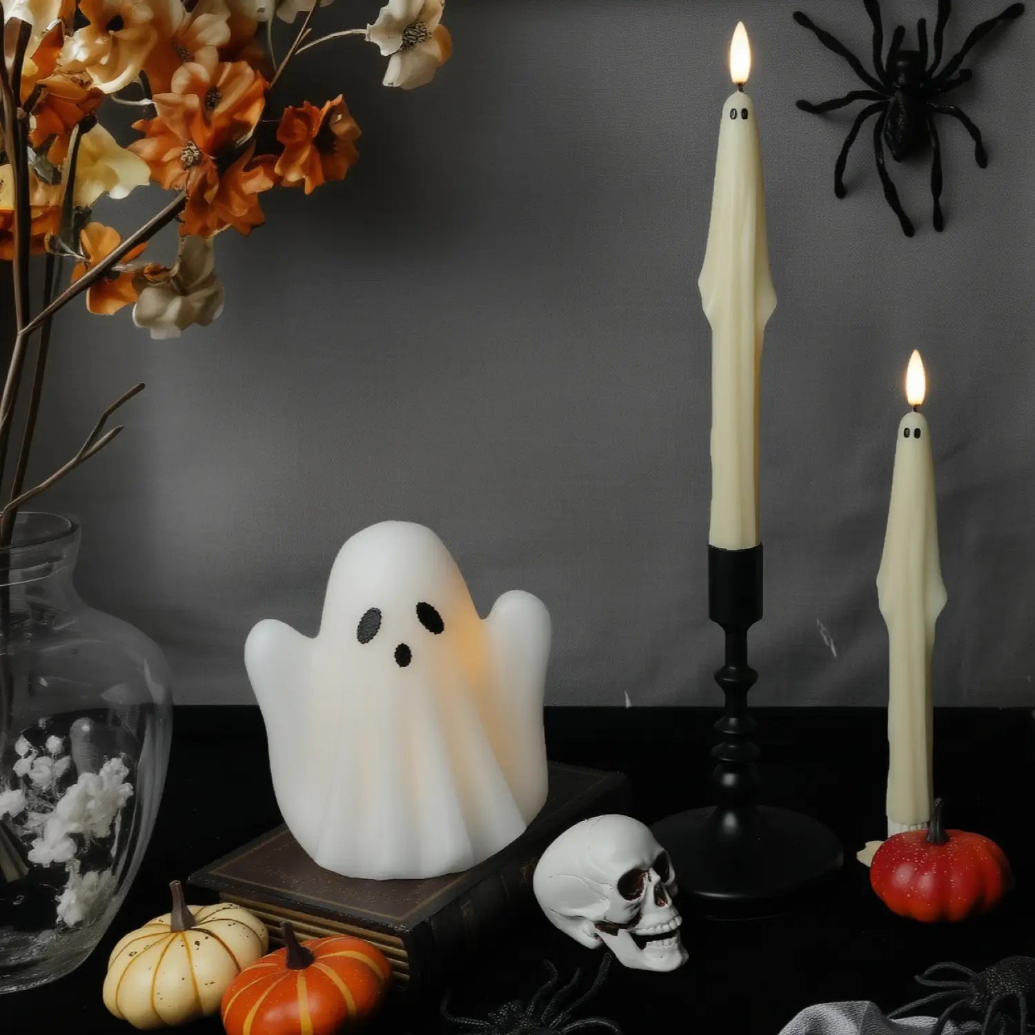 Halloween-themed decor with ghost, candles, pumpkins, and spider.