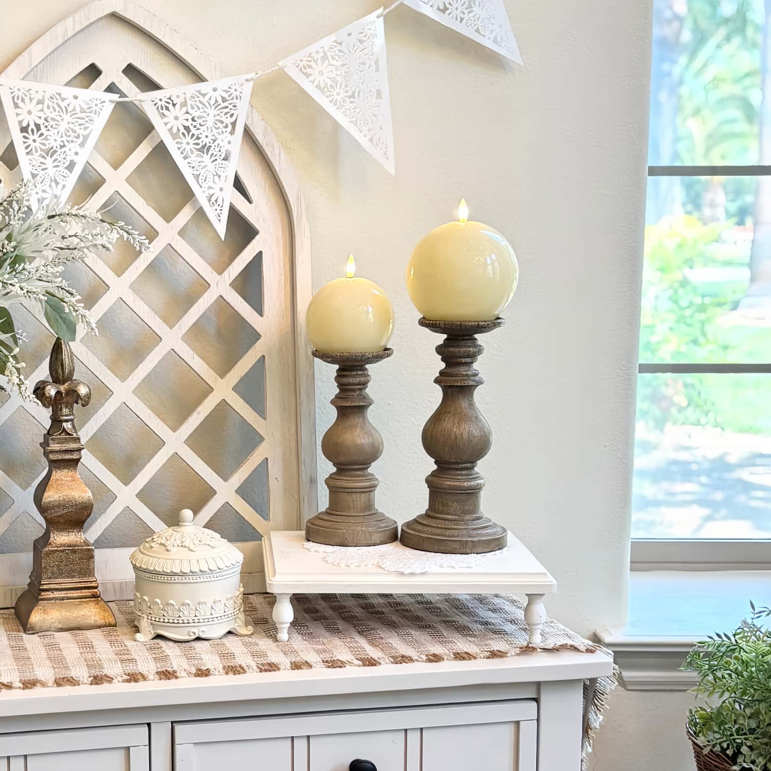 Decorative setup with candles, a mirror, and decorative items on a table.