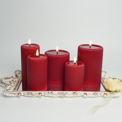 Set of red candles on a decorative tray with a white background