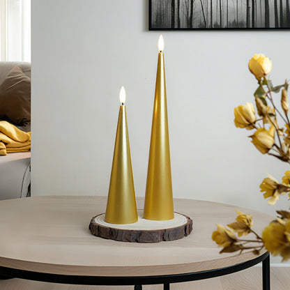 Two gold cone-shaped candles on a wooden base with a blurred background