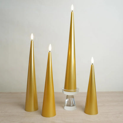 Set of four gold cone-shaped candles on a wooden surface with a plain background