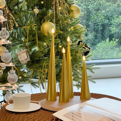 Decorative setup with gold candles, flowers, and greenery on a marble surface.