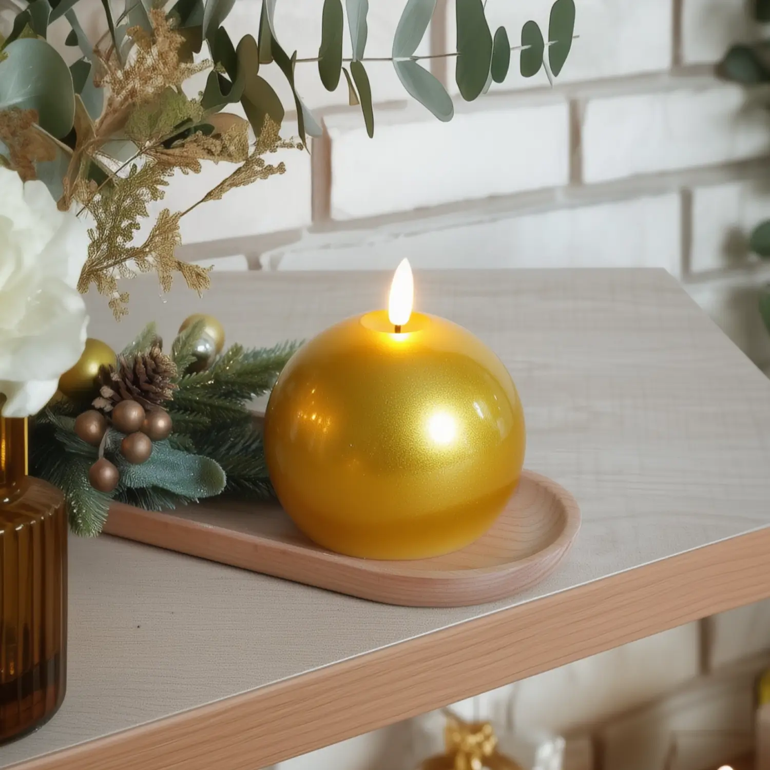 Gold candle on a wooden tray with decorative elements on a table.