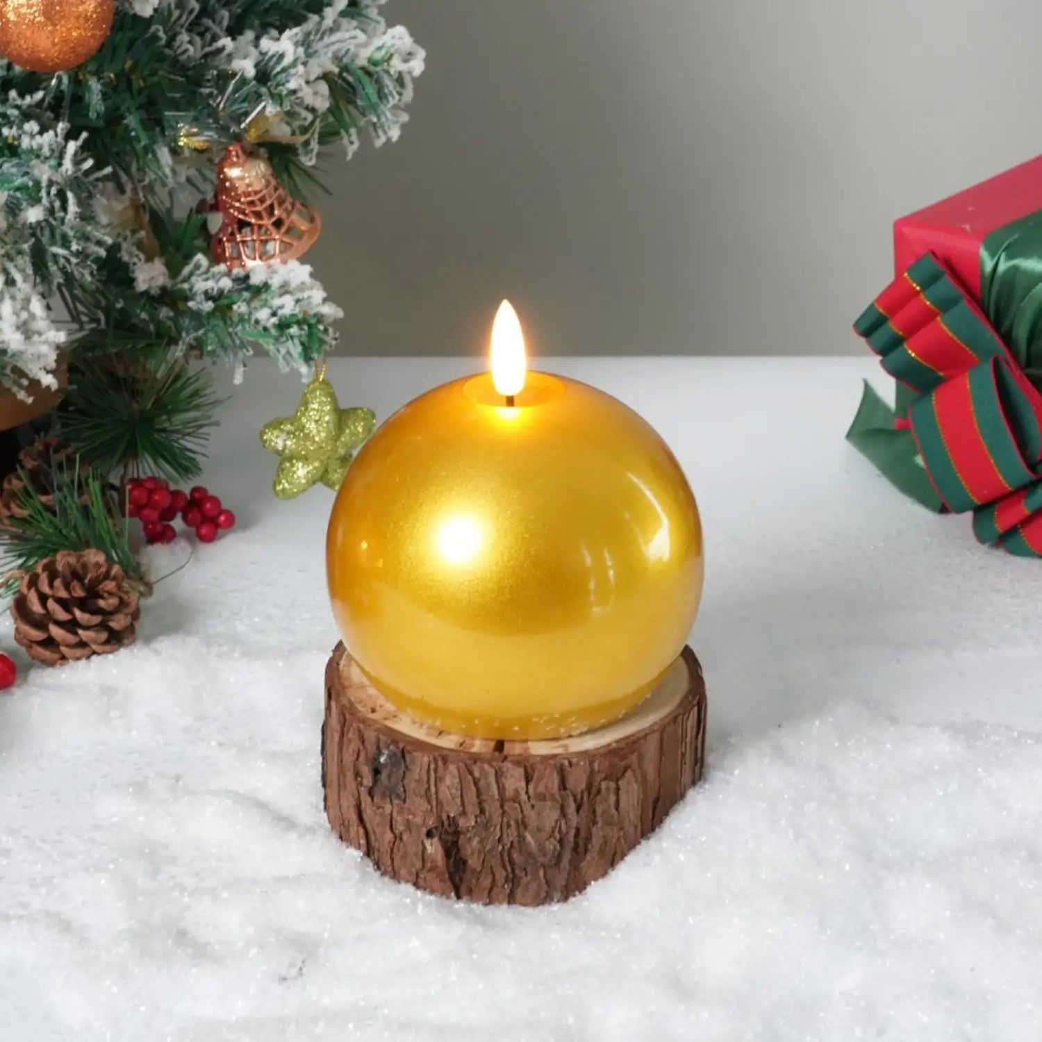 Gold candle on a wooden base with Christmas decorations in the background