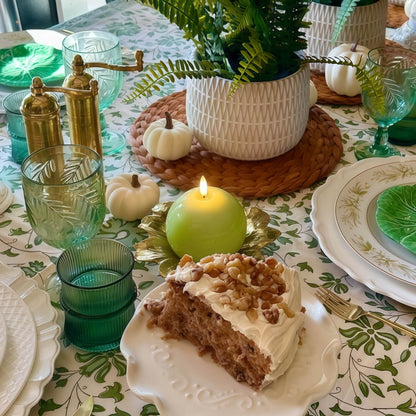 Green candle on a white plate with a white napkin