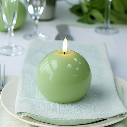 Green candle on a white plate with a white napkin