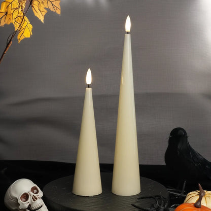 Two white cone-shaped candles with lit wicks on a dark surface with a gray background.